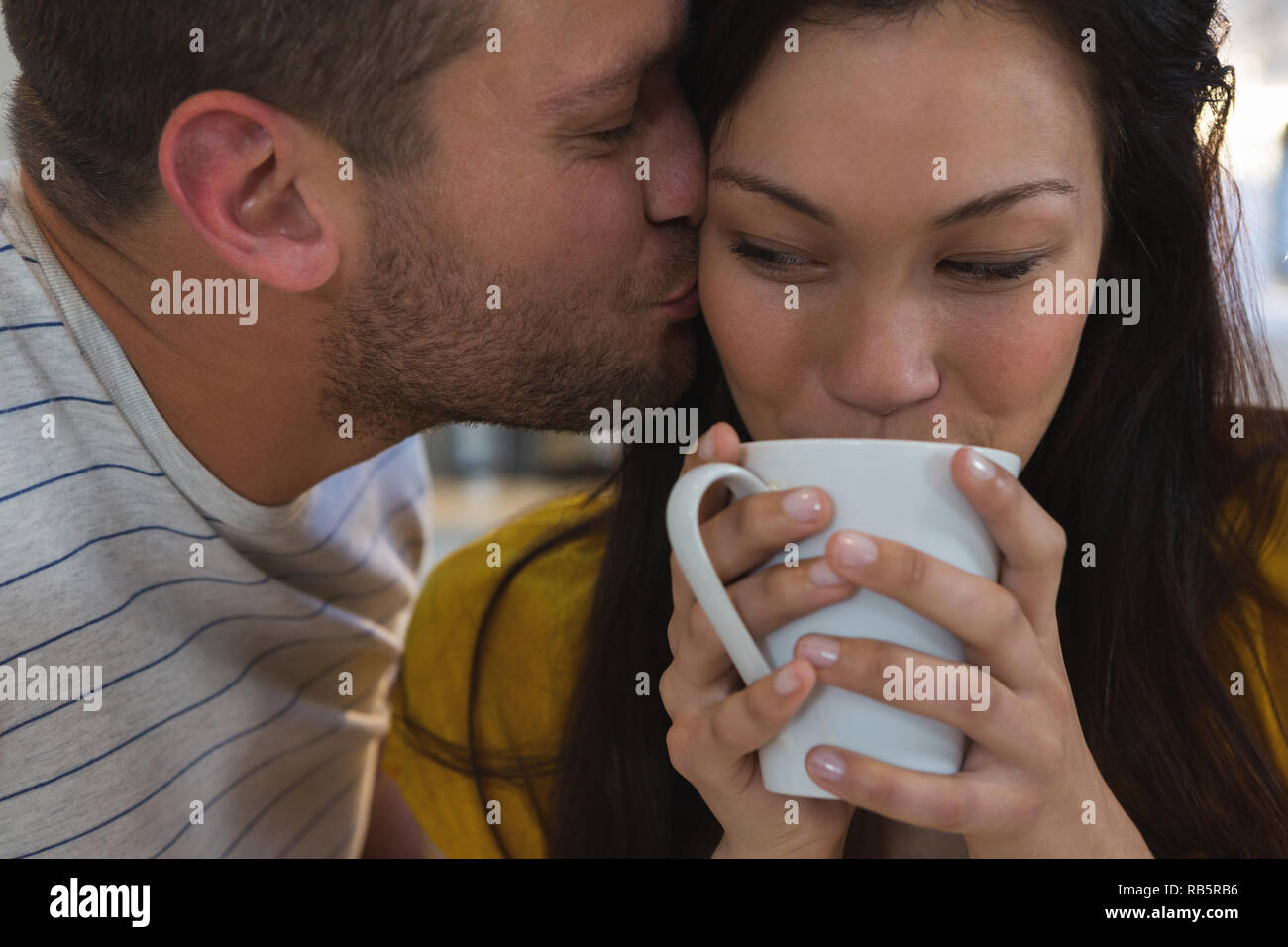 Mann küssen Frau in Küche Stockfoto