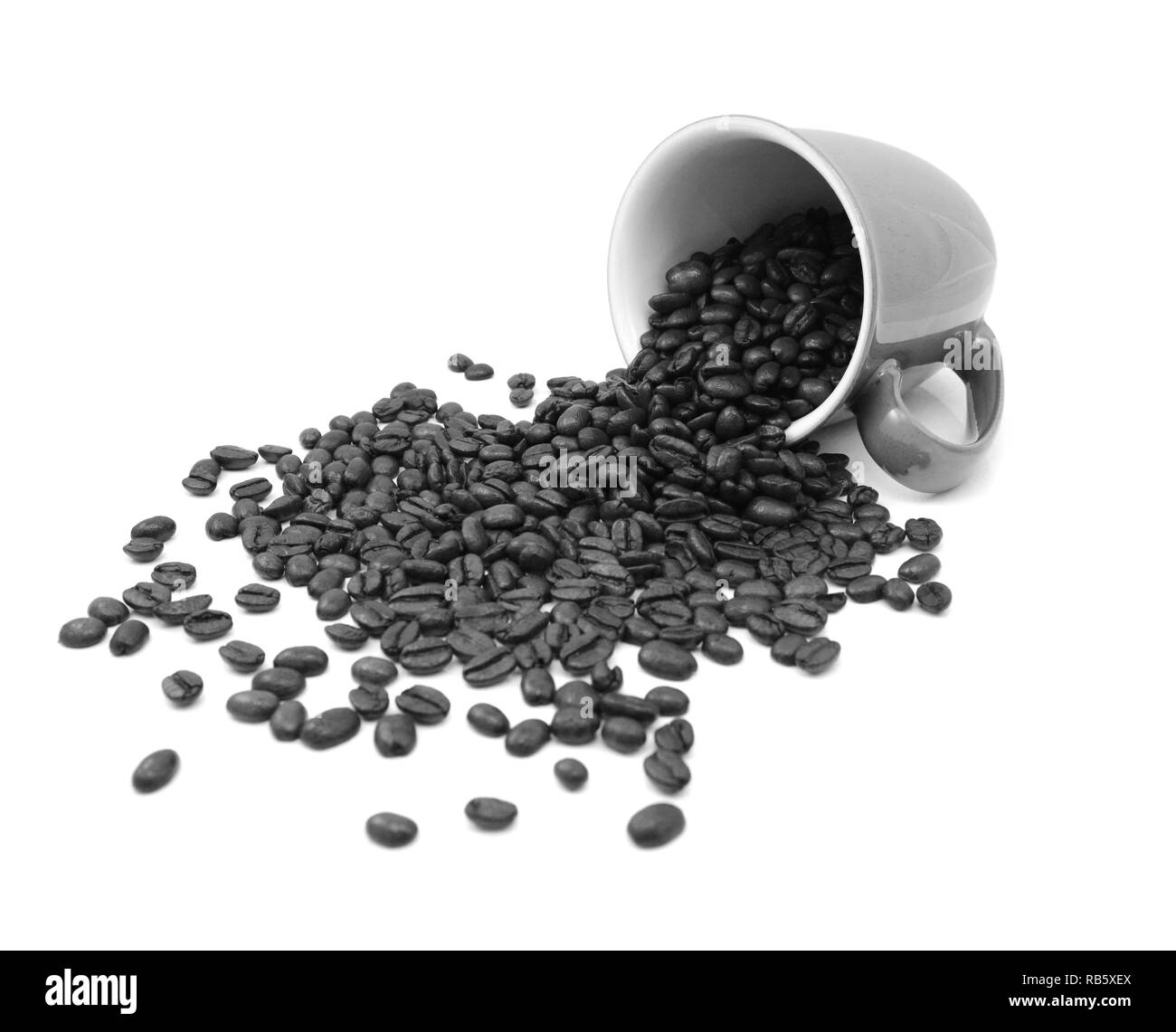 Aromatische geröstete Kaffeebohnen Ausgießen aus einer Tasse auf einem weißen Hintergrund - monochrom Verarbeitung Stockfoto