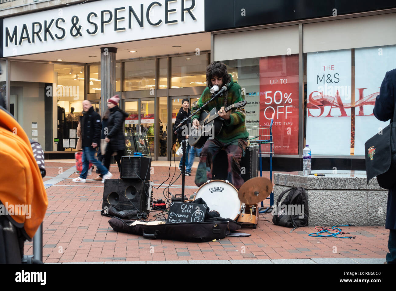 Ein strassenmusikant spielt Musik vor dem Marks und Spencer in der Broad Street in Reading, Großbritannien Stockfoto