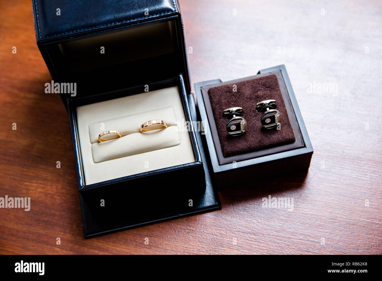 Trauringe in einem schwarzen und weißen Schmuck und Gold Manschettenknöpfe Stockfoto