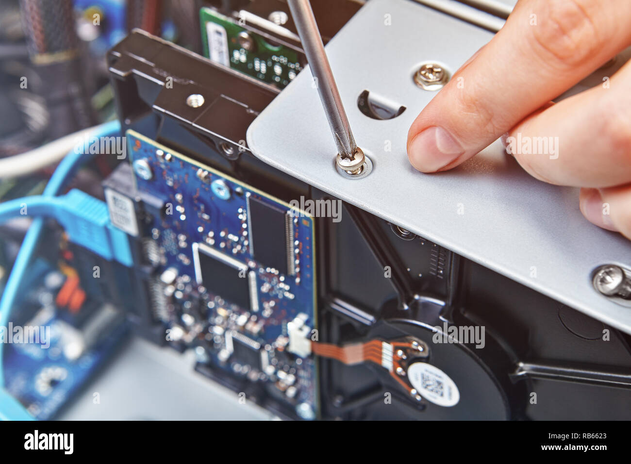 Schlosser ist, lösen Sie die Schraube der HDD der unkonfektionierten Systemeinheit, hautnah. Stockfoto