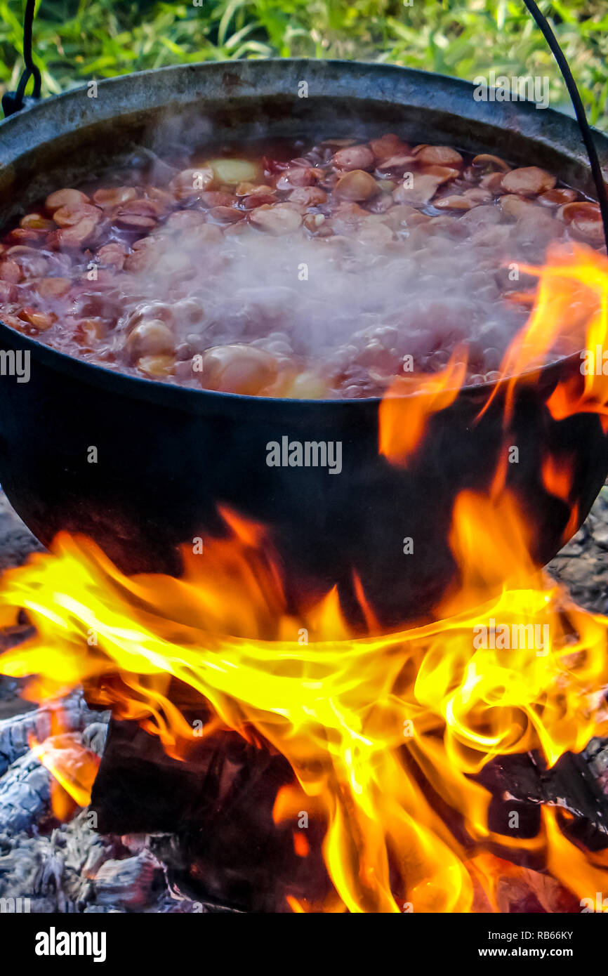 Kochen Suppe aus Gusseisen Kessel am Brennen Lagerfeuer. Topf mit Suppe  über dem offenen Feuer im Freien. Tourismus in Lettland. Kochen Suppe im  Topf am Lagerfeuer Stockfotografie - Alamy