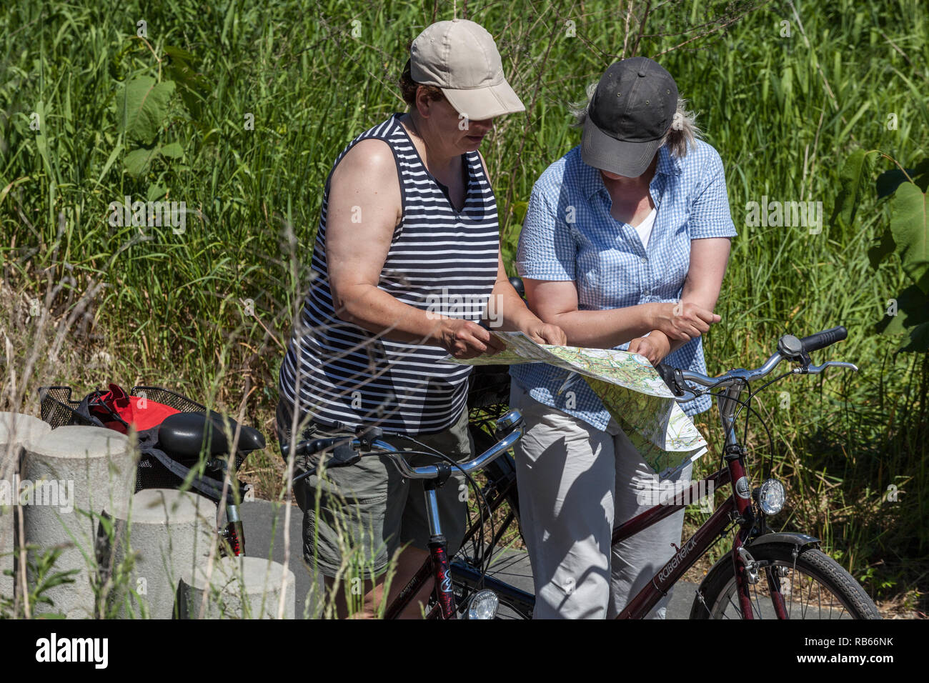 Zwei ältere Frauen auf dem Radweg, Frauen, die sich die Karte ansehen, Radfahrer in Deutschland Stockfoto