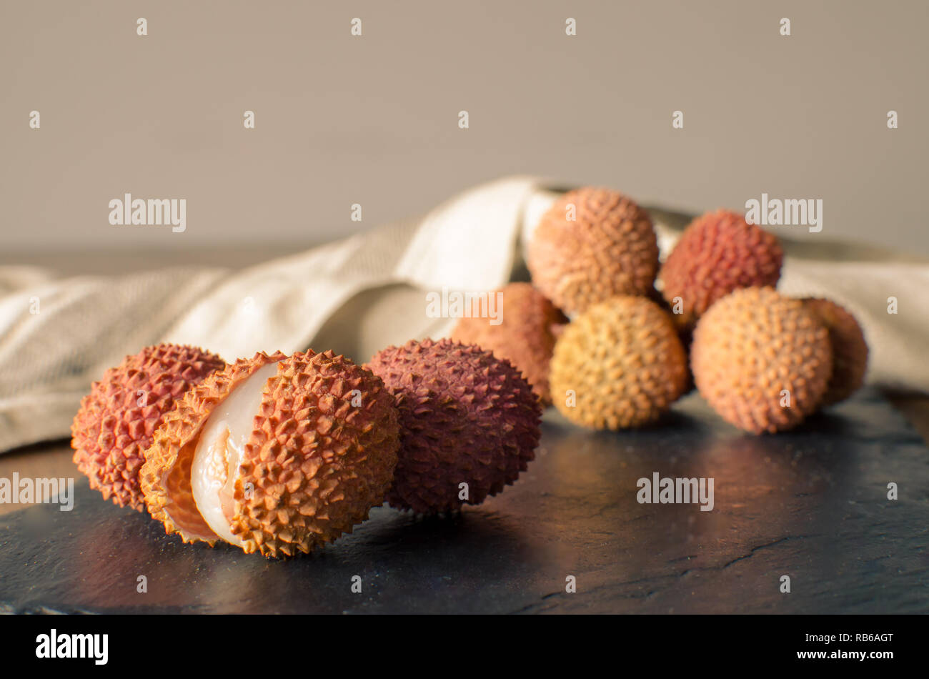 Litschi, lichee, Lychee, oder lichi, Litchi chinensis auf schwarzen Stein Hintergrund Stockfoto