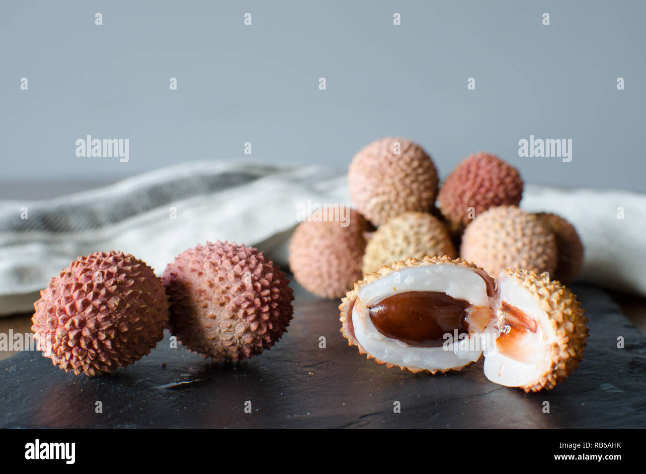 Litschi, lichee, Lychee, oder lichi, Litchi chinensis auf schwarzen Stein Hintergrund Stockfoto