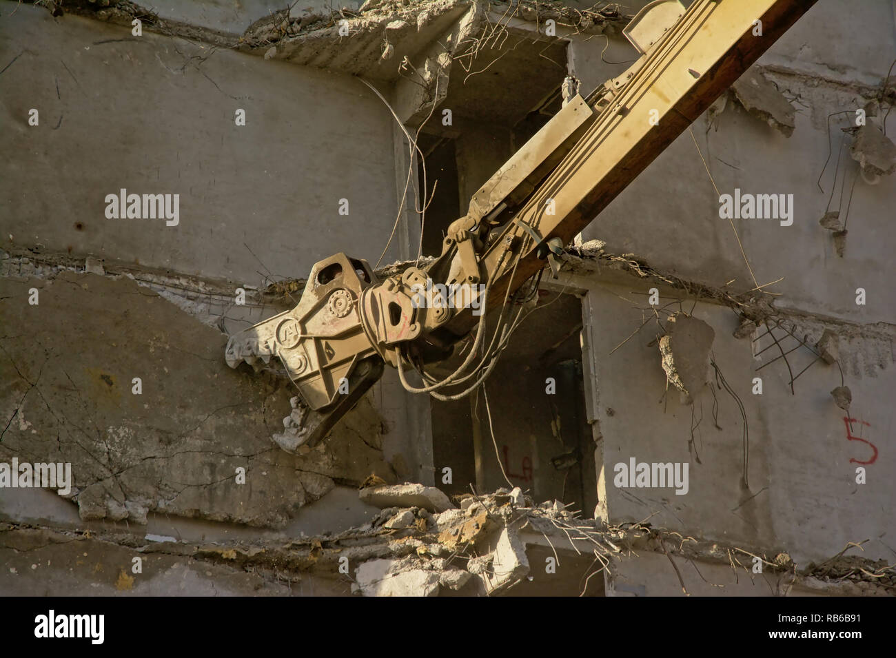 Nahaufnahme von einem gelben Baukran arm Abriss eine abgespeckte konkrete Gebäude, Rabot, Gent, Belgien Stockfoto