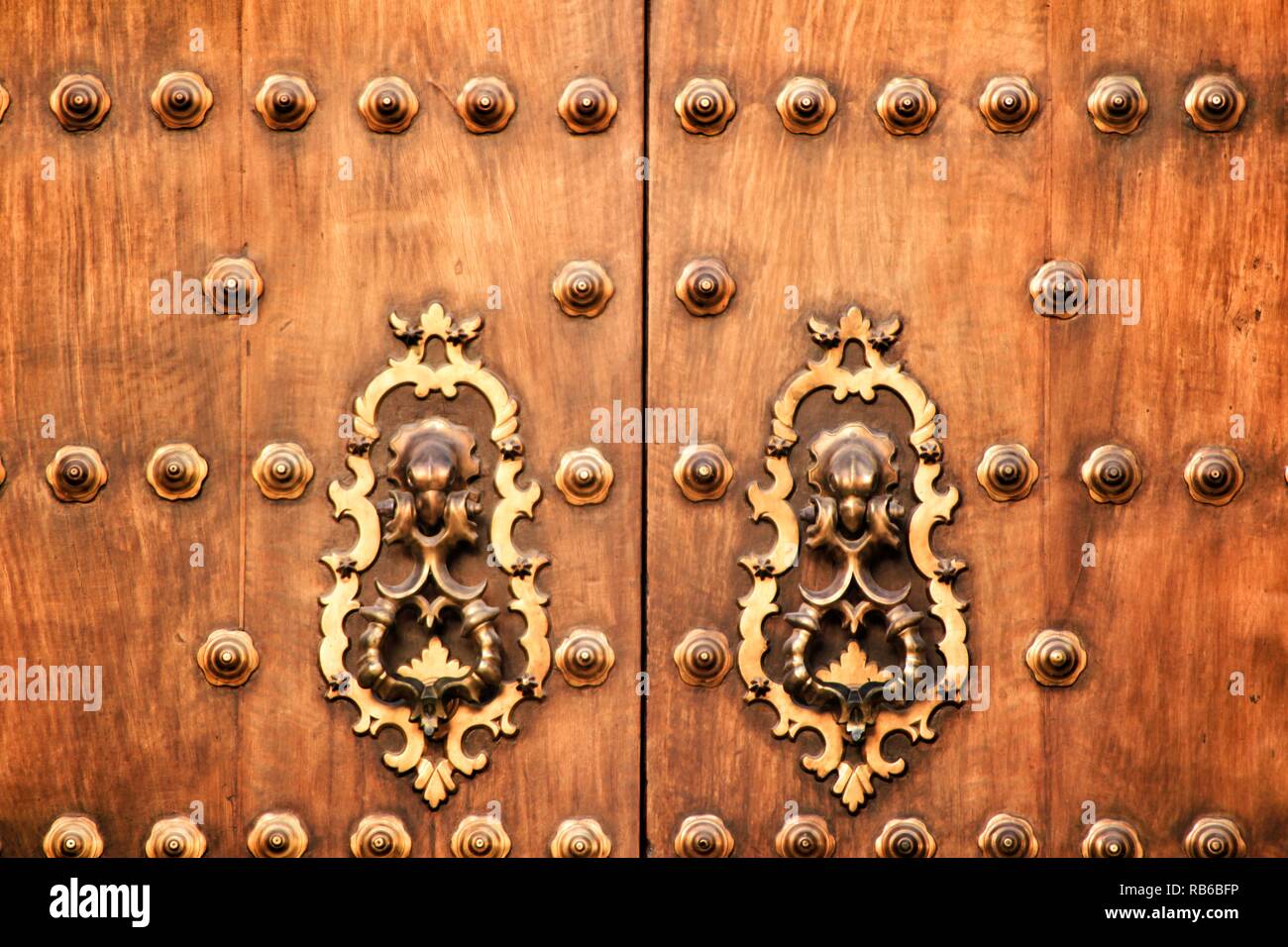 Aus geschmiedetem Metall vintage Golden Door knocker auf braunen Holztür in Cordoba, Spanien Stockfoto