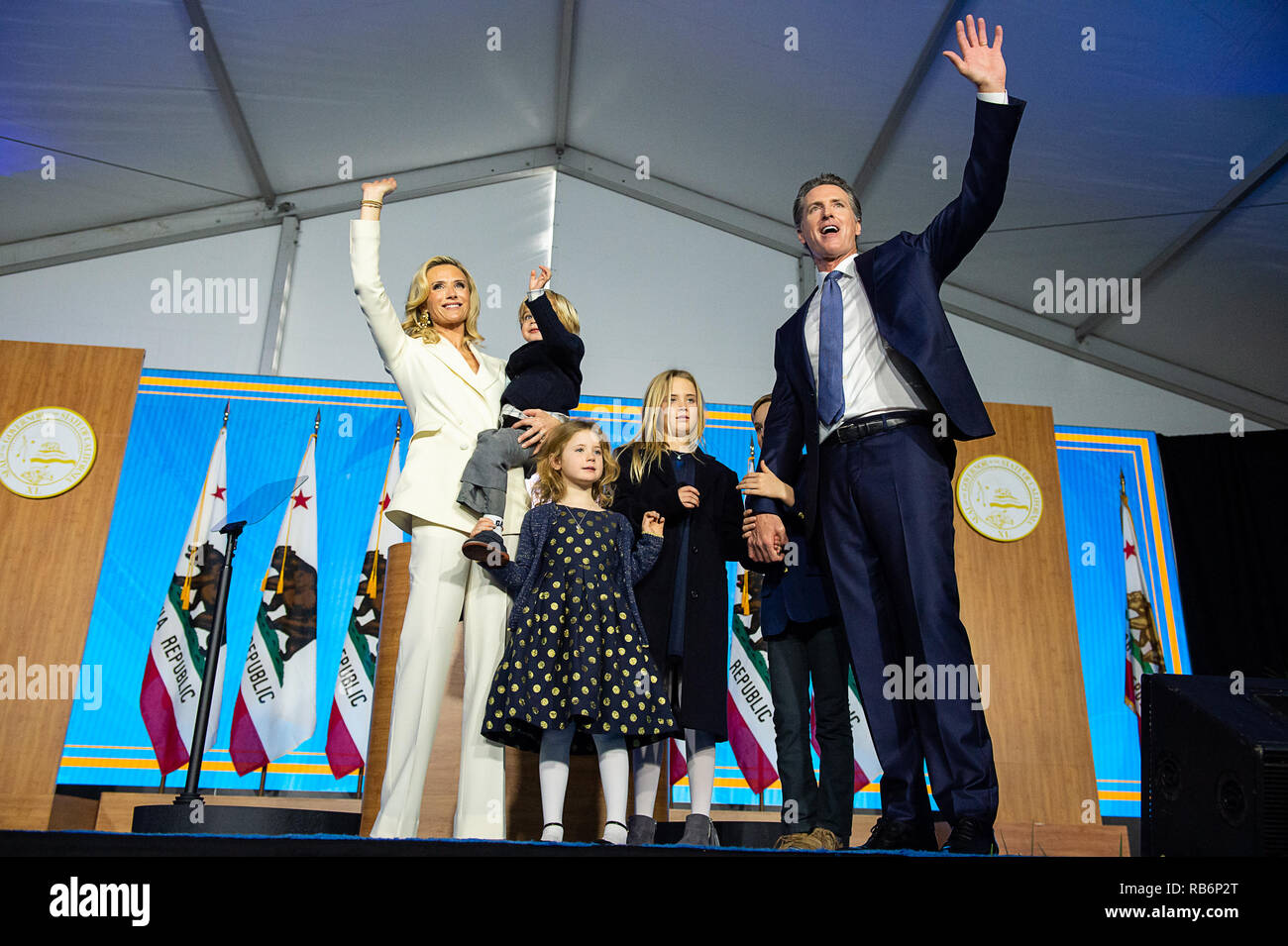 Sacramento, CA, USA. 7 Jan, 2019. Gouverneur Gavin Newsom und erster Partner Jennifer Siebel Newsom Wellen zu der Masse mit Familie 9-year-old Montana, 7-jährige, 5-jährige Brooklynn und 2-year-old Dutch, nachdem er geschworen wurde als 40. Der Gouverneur von Kalifornien während der Einweihung an der Landeshauptstadt am Montag, 7. Januar 2019 in Sacramento. Credit: Paul Kitagaki jr./ZUMA Draht/Alamy leben Nachrichten Stockfoto