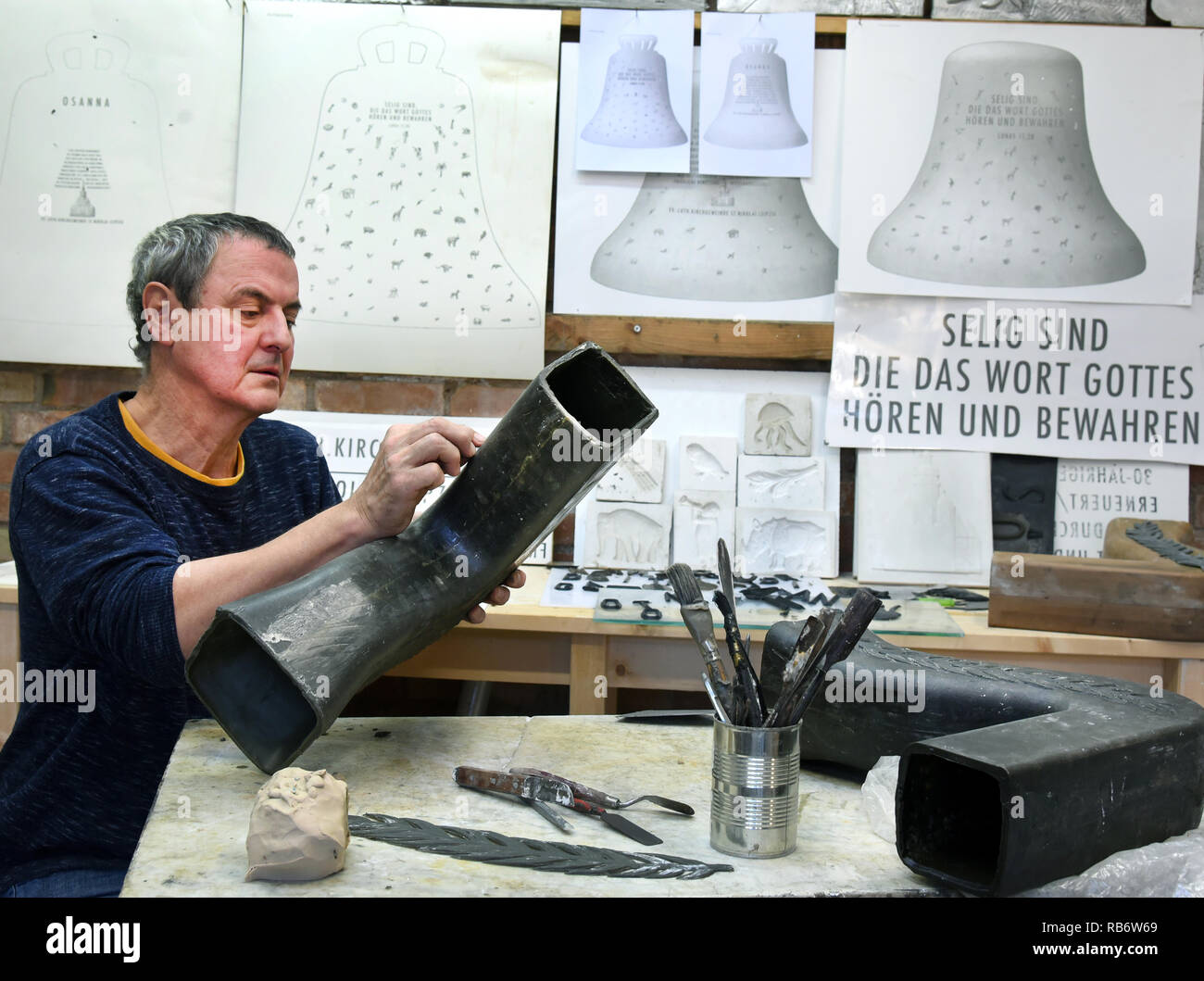 07 Januar 2019, Sachsen-Anhalt, Sachsen-Anhalt, Landkreis Höhnstedt: Der Bildhauer Carsten Theumer arbeitet in seinem Studio in Sachsen-Anhalt, OT Höhnstedt, bei der Gestaltung einer Krone für das Bell'Osanna'. Die Glocke ist in der 30. Jahrestag der friedlichen Revolution am 9. Oktober 2019 in den südlichen Turm der Nikolaikirche in Leipzig zu klingeln. Die sechs Tonnen schwere bronzene Glocke mit einem Durchmesser von 2,14 Metern und einer Höhe von zwei Metern werden dann zu einer teilweise vorhandenen Bell Ensemble von acht Glocken gehören. Die neue "osanna" durch über 80 Tiere aus der ganzen Welt geschmückt, Pflanzen, Blumen, Palmen, Engel p Stockfoto