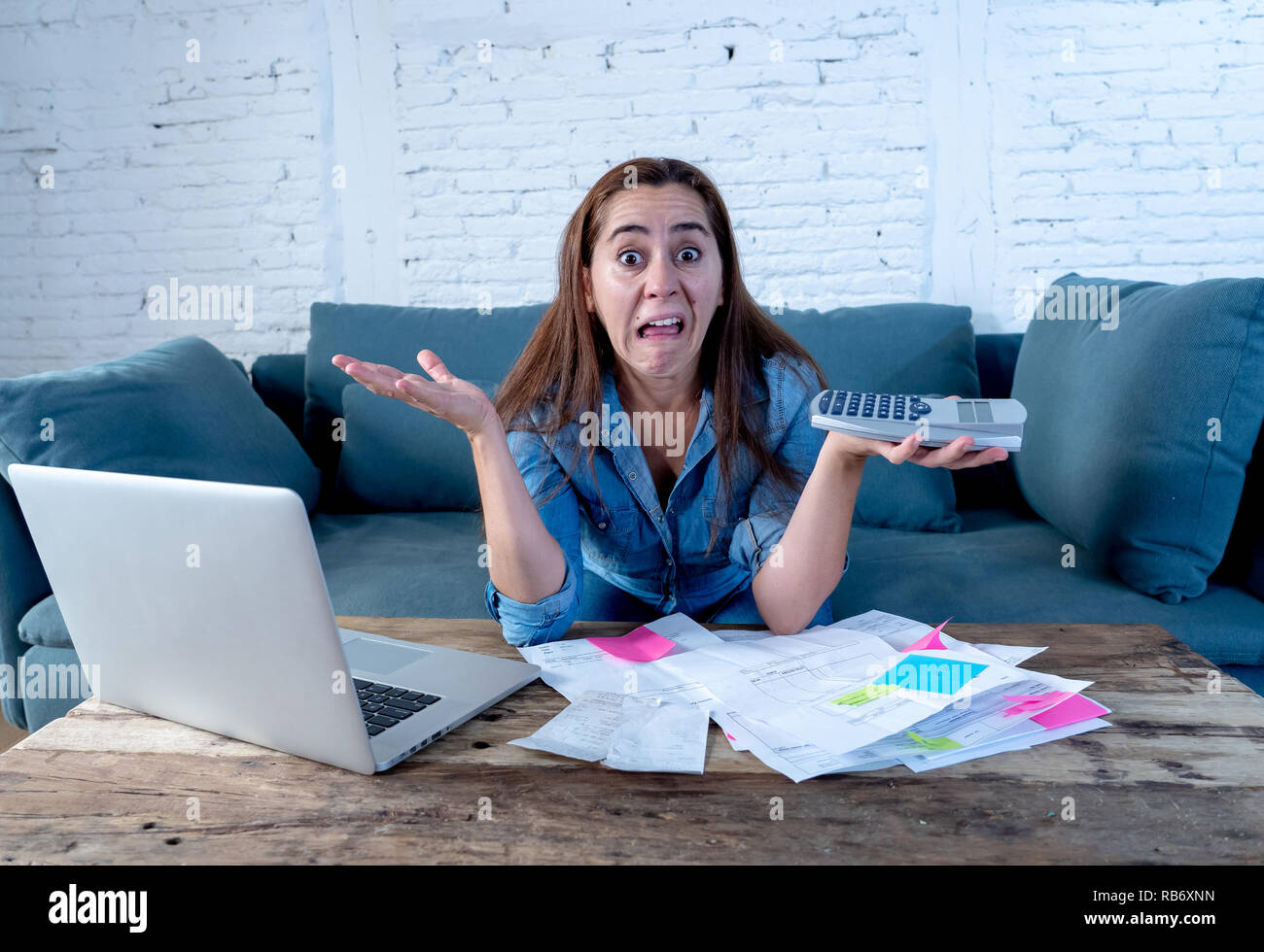 Porträt der jungen alleinerziehenden Mutter Business woman Stress Buchhaltung Finanzen mit Laptop und Rechner im Wohnzimmer in die Zahlung von Schulden und Stockfoto