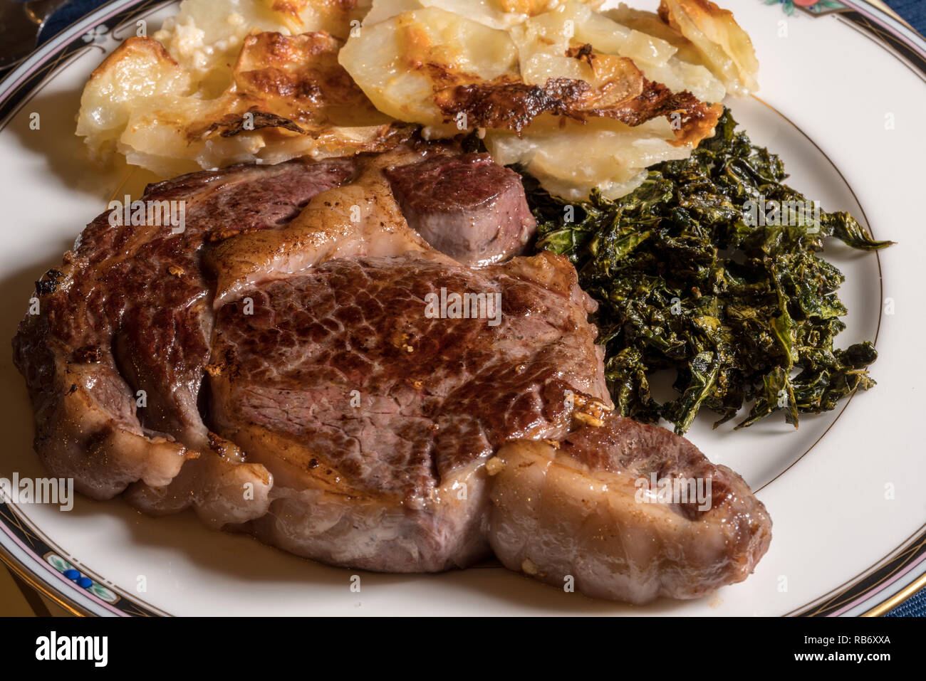 Große Rib Eye Steak auf weiße Platte mit Grünkohl und Kartoffeln Stockfoto