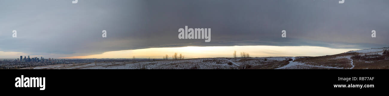 Chinook Bogen über dem Nose Hill Park, geformt von Wolken aus einem warmen, trockenen Wind, der aus dem lee of the Rocky Mountains und der Skyline von Calgary in der Ferne stammt Stockfoto