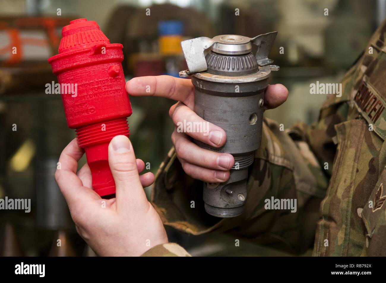 Senior Airman Nathanael Banden-industrie, 4. Bauingenieur Squadron die Beseitigung von Explosivstoffen Techniker, vergleicht eine M904 Bombe Nase Fuze auf seine 3D-gedruckten Gegenstück, Dez. 14, 2016, bei Seymour Johnson Air Force Base, North Carolina. Mit der Fähigkeit, um den Einsatz der kostengünstigen Kunststoffen produzieren, EOD-Techniker können schneiden, Scheren, Punktion oder komplett ein Training Munition voll eine Übung ohne finanzielle Auswirkungen vollständig auslöschen. Stockfoto