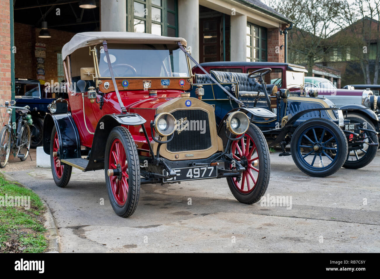 Linie der Oldtimer außerhalb einer Garage im Bicester Heritage Center. Bicester, Oxfordshire, England Stockfoto