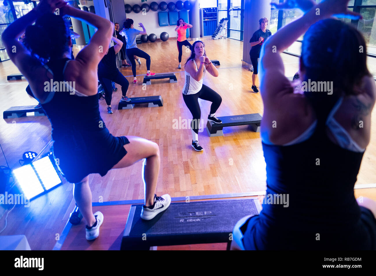 Ausbilder in Step Aerobic-Fitness-Klasse in der Turnhalle Stockfoto