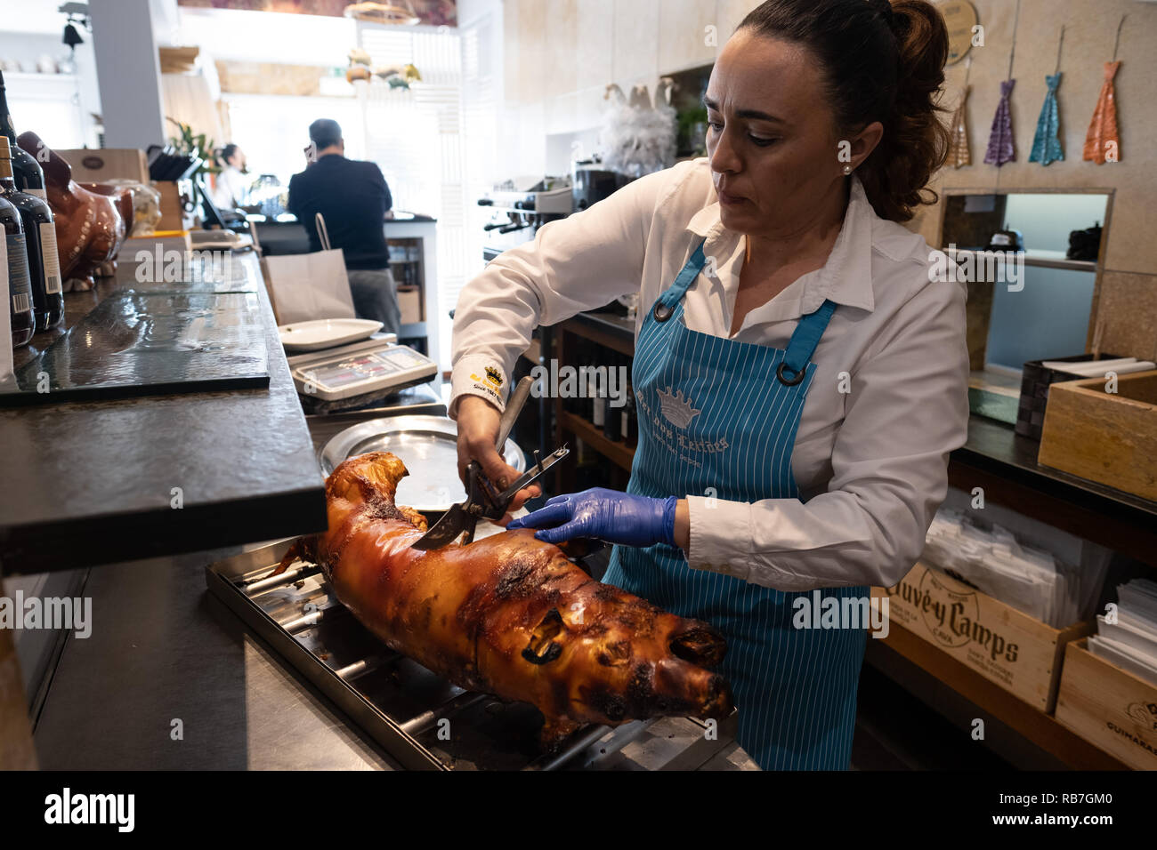 Frau vorbereiten ein Ferkel, die in traditionelle portugiesische Bairrada Weise geröstet wurde für den Dienst an der Rei Dos Leitões Restaurant, Setúbal, Portugal Stockfoto