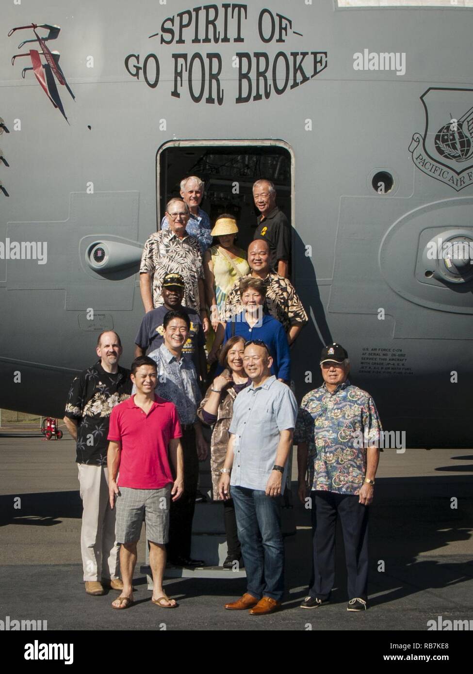 Eine Gruppe von Besuchern, die die 100 Infanterie Bataillon und der 442Nd Regimental Combat Team, geführt von pensionierten Generalmajor Robert G.F. Lee, posieren für ein Gruppenfoto vor der US Air Force C-17 Globemaster III Lager ihre Namensvetter der 'Geist von Gehen für Brach' bei einer gemeinsamen statische Flugzeuge Anzeige auf der Flightline Dez. 6, 2016, in: Joint Base Pearl Harbor-Hickam, Hawaii. Während des Zweiten Weltkriegs, der 442Nd war eine hoch dekorierte Infanterie Einheit, bestehend aus Amerikanern japanischer Abstammung, die Aktion sah und kämpfte in Italien und Frankreich. Stockfoto