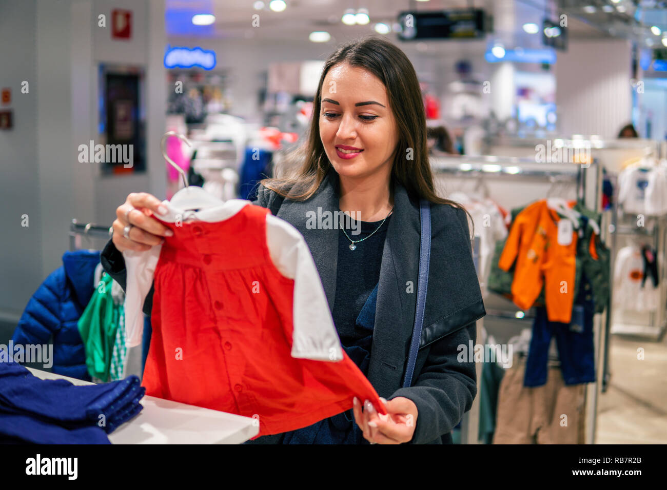 Kunden Frau Wahl Baby Kleidung im Shop Stockfoto
