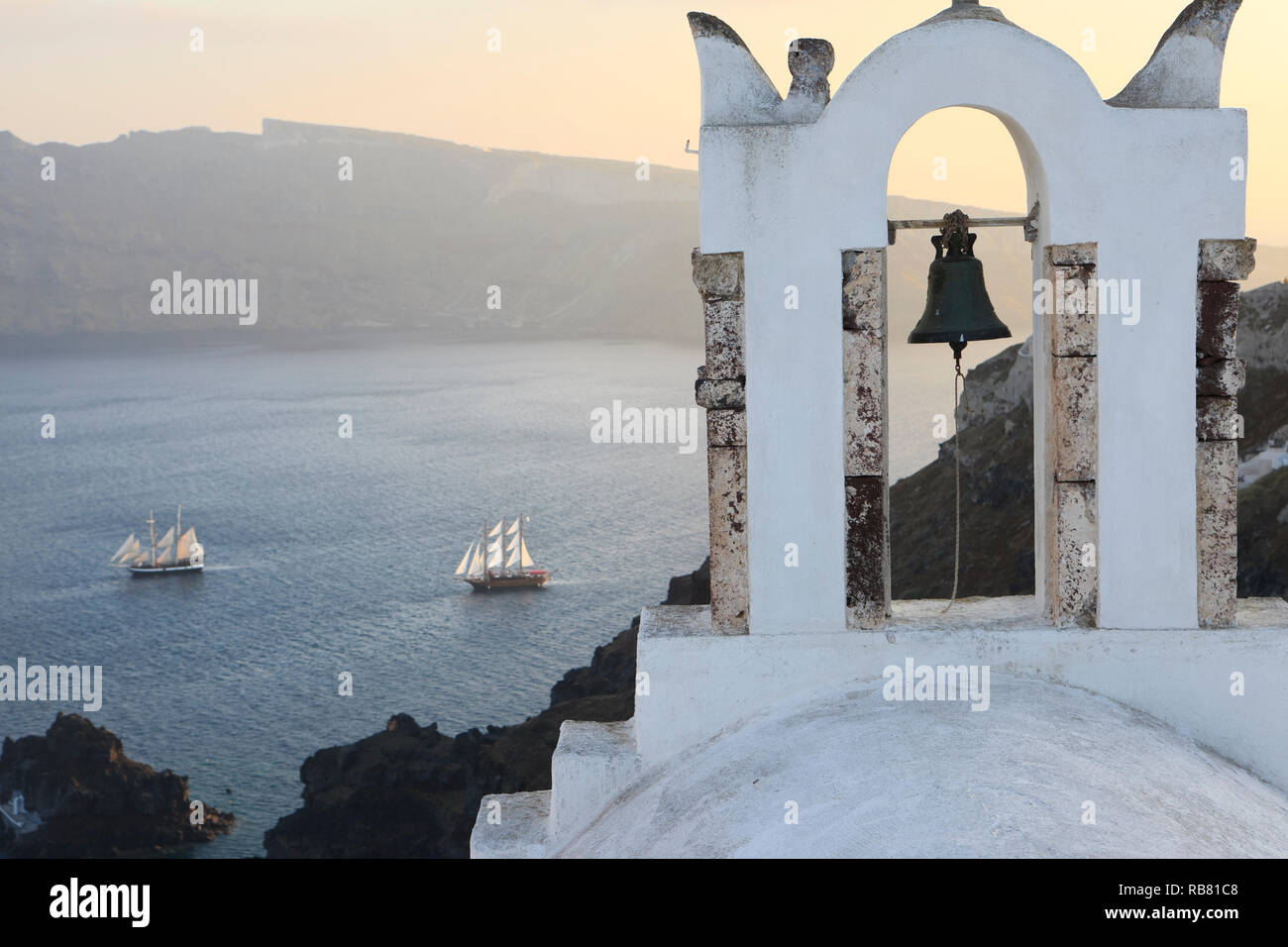 Stadt Oia auf Santorin. Blick auf Kirche mit Glockenturm auf dem Vulkan Rim (Caldera). Segeln auf dem Mittelmeer unten Stockfoto