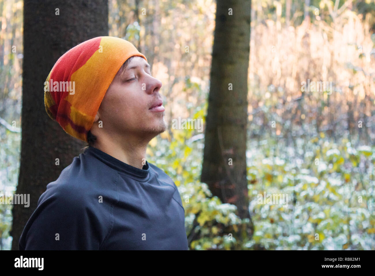 Porträt eines jungen Mannes mit geschlossenen Augen in den Wald. Stockfoto