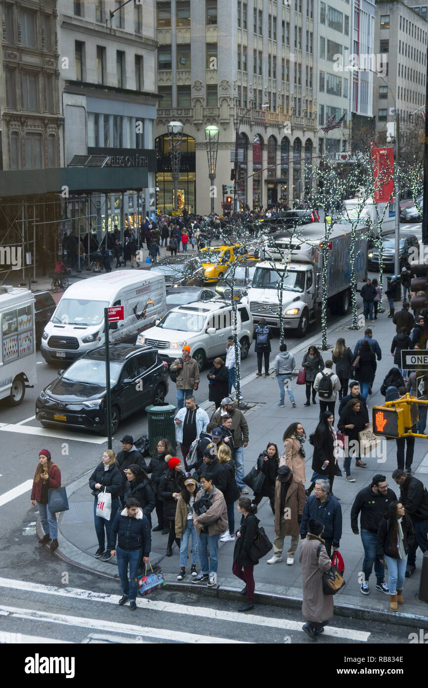 Fußgänger und den Straßenverkehr entlang der 5th Avenue at 46th Street während der Weihnachtszeit in Midtown Manhattan, New York City. Stockfoto