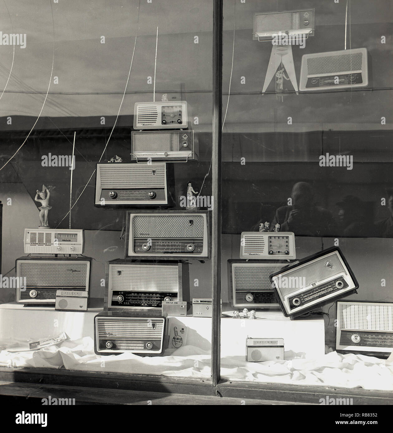 1950s, historisch, Peking, China. Elektrisches Schaufenster mit einer Anzeige der neuesten Transistor-Radios. Anfang 1950s war das Transistorradio ein revolutionäres Stück Technologie, das den Menschen, insbesondere den jungen, erstmals musikalische Freiheit gab und die asiatischen Hersteller begannen, die ursprünglich aus den USA lizenzierte Technologie zu nutzen, um Konsumgüter zu wettbewerbsfähigen Preisen zu entwickeln. Stockfoto