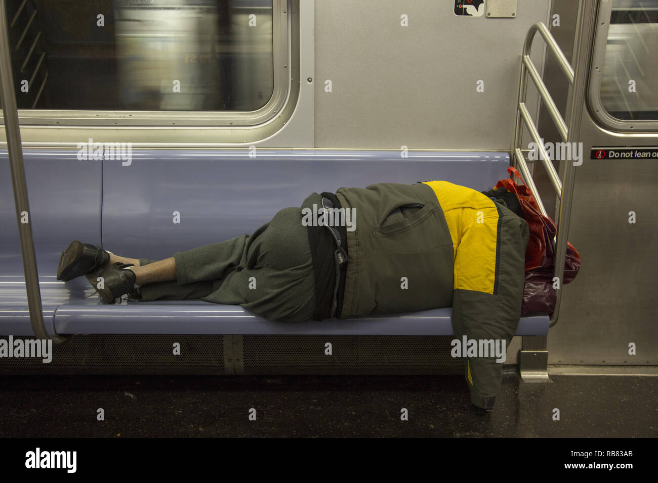 Obdachlose schlafen auf New York City und U-Bahn, besonders am Morgen, wenn die Menschen zur Arbeit zu gehen. Stockfoto