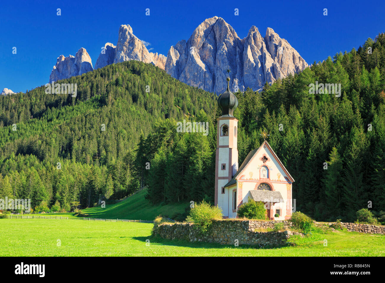 Die Kirche St. Johann in Ranui in der Villnoess/Villnöss Tal in den Dolomiten, Südtirol, Italien. Im Hintergrund die Geisler Gruppe Berg Rang Stockfoto