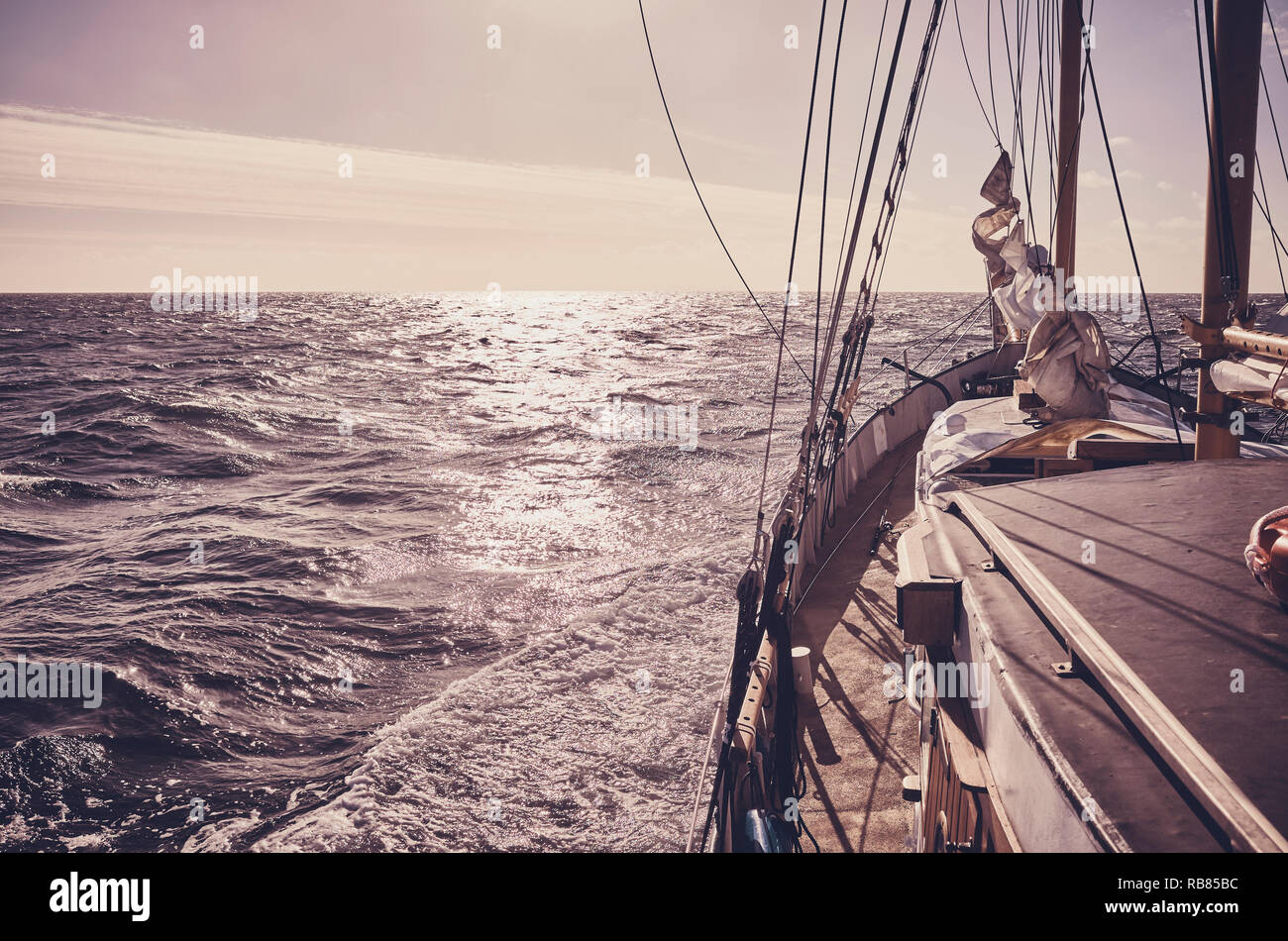 Alte schoner Segeln bei Sonnenuntergang, Reisen und Abenteuer Konzept, Farbe getonte Bild. Stockfoto