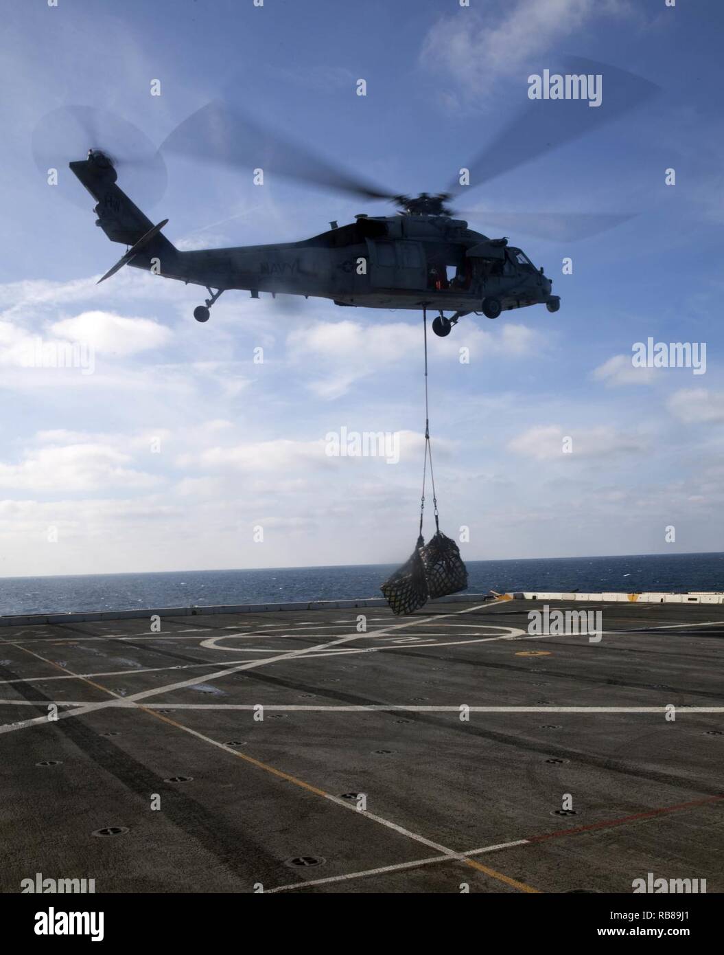 Ein MH-60S Seahawk Hubschrauber liefert cargo Paletten zu USS Mesa Verde LPD (19) von der USS Big Horn (T-AO 198) Am 8. Dezember 2016 während der Ausführung eines vertikalen Nachschub während der Amphibischen bereit Gruppe Marine Expeditionary Unit Übung Dez. 8, 2016. Während der dreiwöchigen Ausbildung evolution, Marines wird eine breite Palette von Maßnahmen und Szenarien die Verbesserung der Interoperabilität und amphibische Kriegsführung Fähigkeiten mit ihren Marine Pendants bekämpfen. Auffüllung auf See ist entscheidend für die bataan Amphibious Ready Gruppe selbst unterstützen, während im Gange. Stockfoto