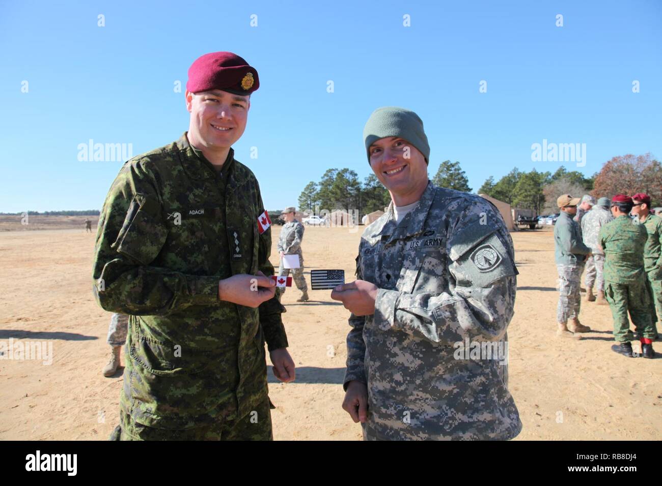 Kapitän Andrew Adach, Kanadische Armee Advanced Warfare Center, bereitet die Flags, die mit einem US-Armee Matthew Kreps, Mächtigen 1-18 th Military Police Company in der Luft, während ein Betrieb für die 19. jährlichen Randy Oler Memorial Betrieb Spielzeug Drop auszutauschen, bewirtet durch die US-Armee die zivilen Angelegenheiten & psychologische Operations Command (Airborne), auf Luzon Drop Zone, N.C., 10.12.2016. Betrieb Spielzeug Drop ist der weltweit größte kombinierten Betrieb und gemeinsame Aus- und Fortbildung mit acht Partner - nation Fallschirmjäger teilnehmen. Stockfoto