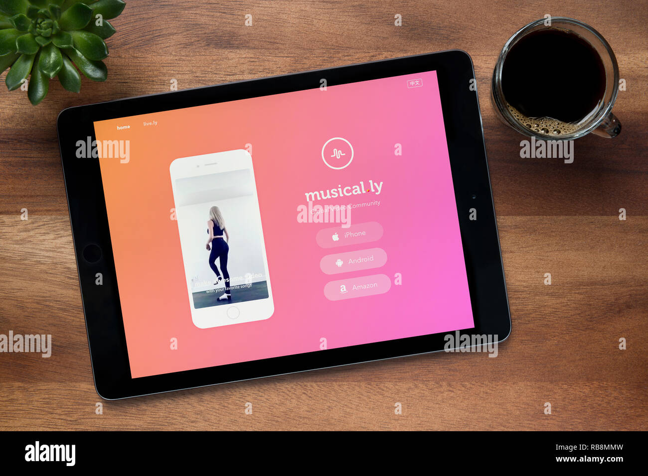 Die Website von musikalischen.ly ist, auf einem iPad Tablet gesehen, auf einer hölzernen Tisch zusammen mit einem Espresso und einem Haus Anlage (nur redaktionelle Nutzung). Stockfoto