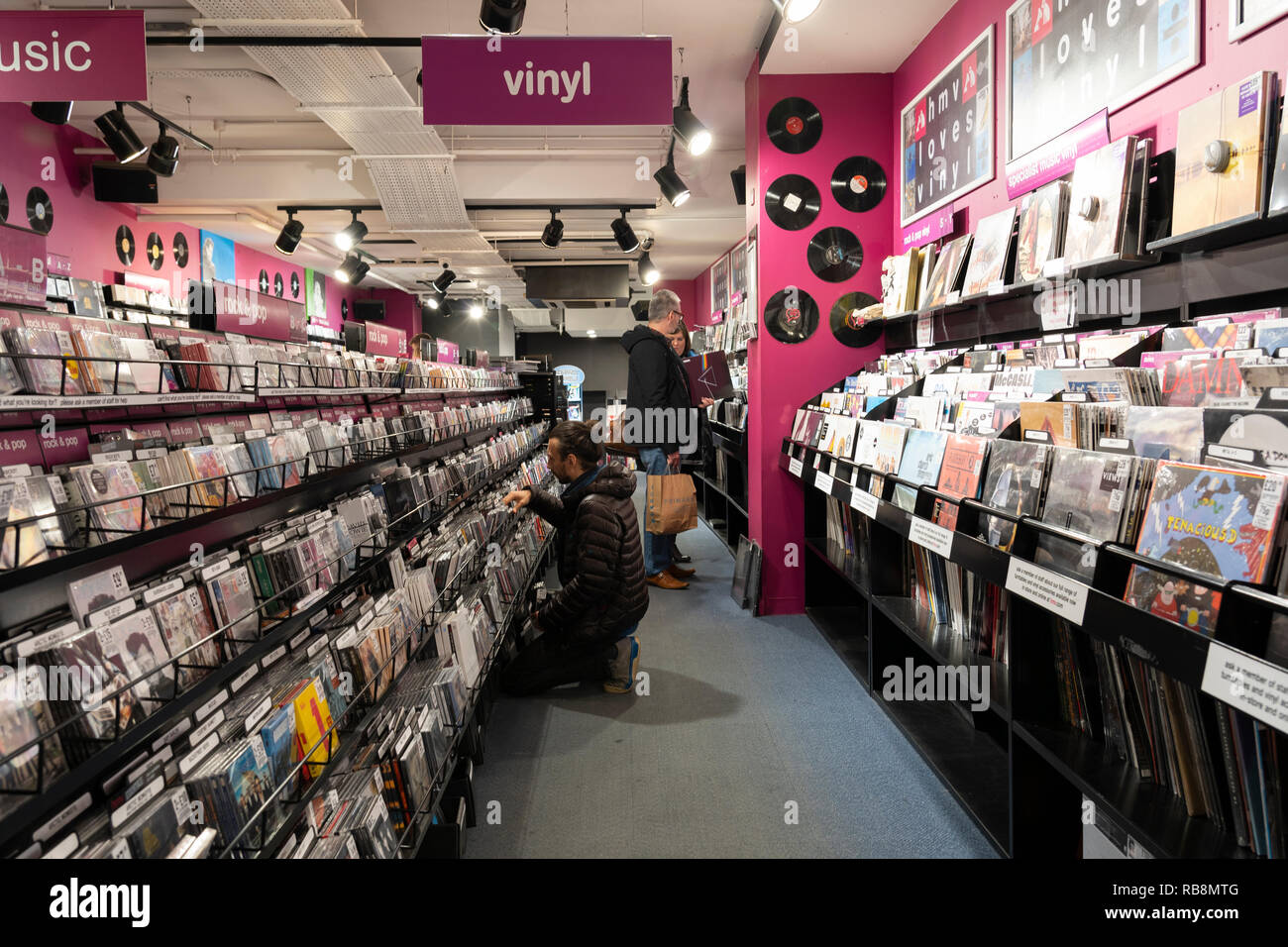 Kunden, die Musik - CDs und Vinyl in HMV, einer Kette von Musik- und Computerspielläden, Worcester, Großbritannien, durchsuchen Stockfoto