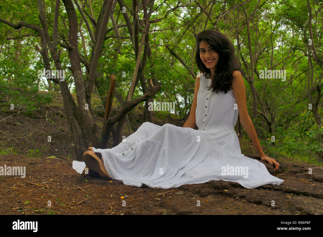Junge Dame im weißen Kleid an Kamera lächelnd, Pashan Tekdi, Pashan Sus-Straße, Pune, Indien Stockfoto