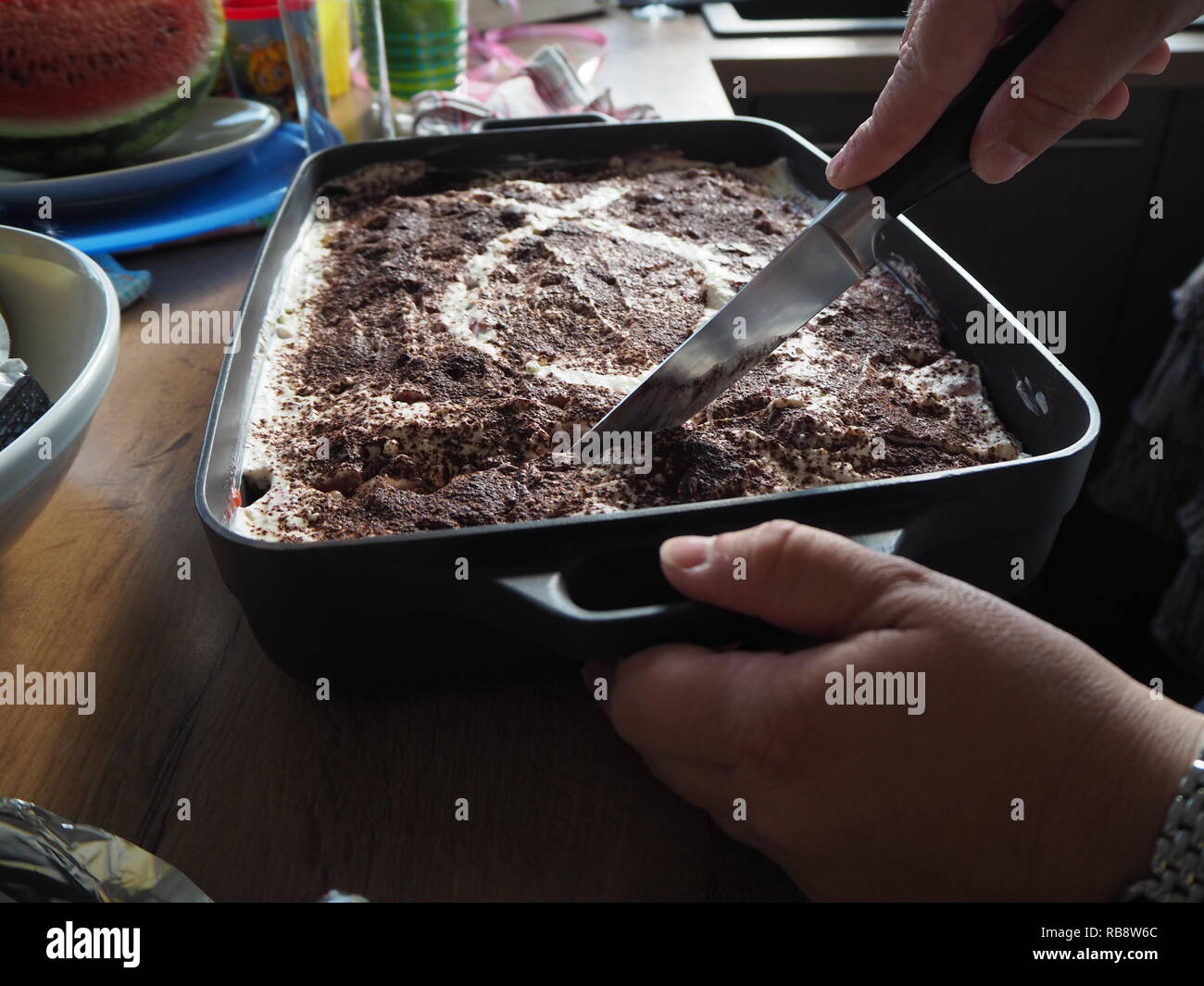 Haus Frau Schneid- und Vorbereitung von Tiramisu. Stockfoto