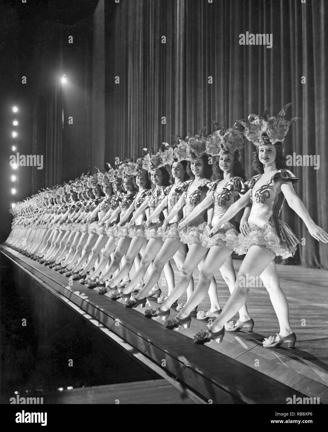 Ballett Mädchen in New York. Eine lange Linie der tanzende Mädchen auf der Bühne in der Radio City Music Hall in New York sind gemeinsam in Bewegung zur Musik synchronisiert. 1940 s Stockfoto