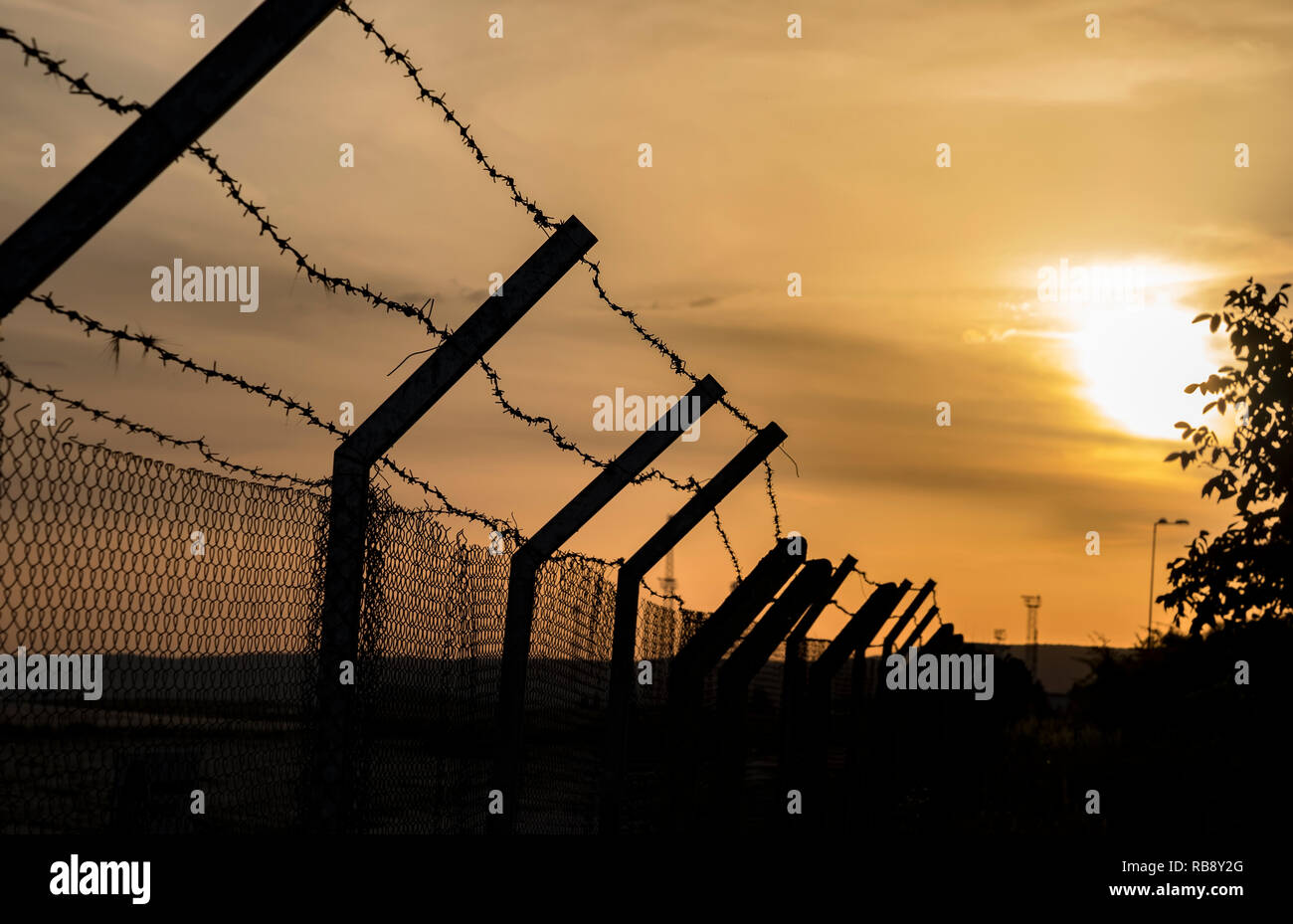 Silhouette der Stacheldrahtzaun bei Sonnenuntergang Stockfoto