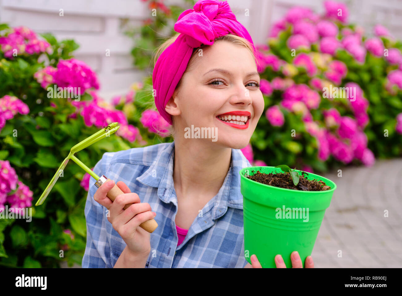 Frau Pflege von Blumen im Garten. glückliche Frau Gärtner mit Blumen