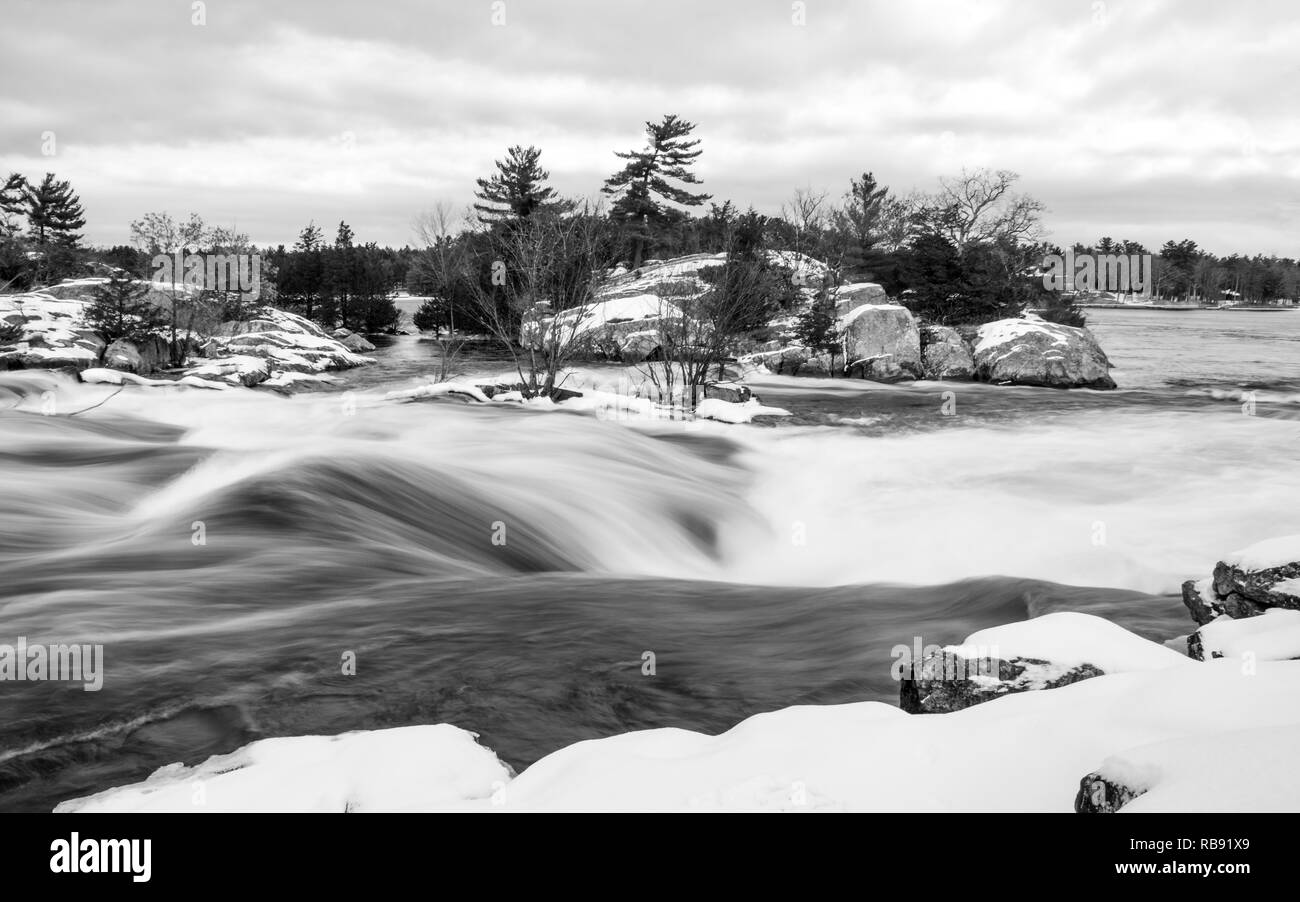Ein schwarz-weiß Bild von Burleigh fällt im Winter, wie das kalte Wasser purzelt unten über den Felsen in eine Unschärfe von Buckhorn See Stoney See. Stockfoto
