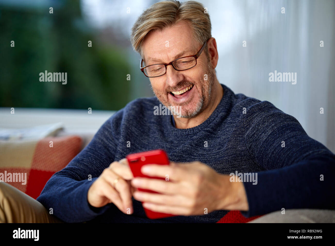Man entspannende Blick durch sein Telefon Stockfoto