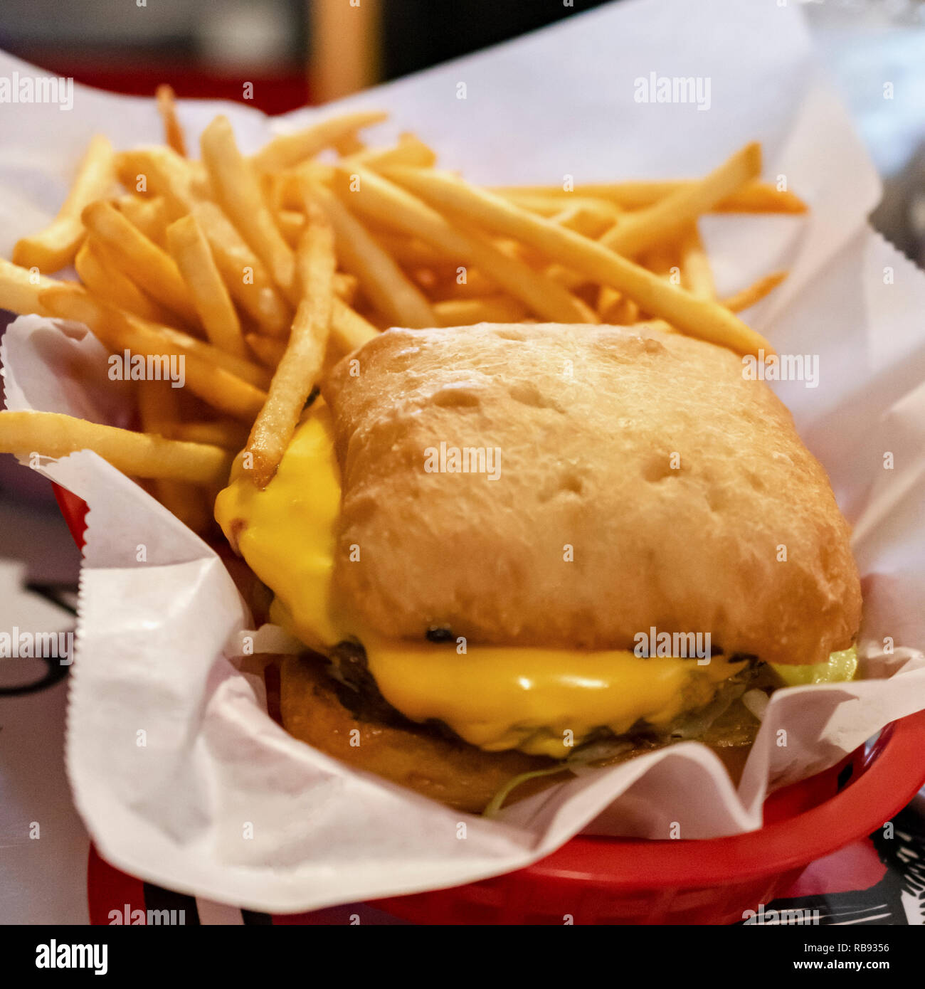 Das Essen in der Bar: gegrillte Burger mit Brötchen und Frys in einem Korb. Stockfoto