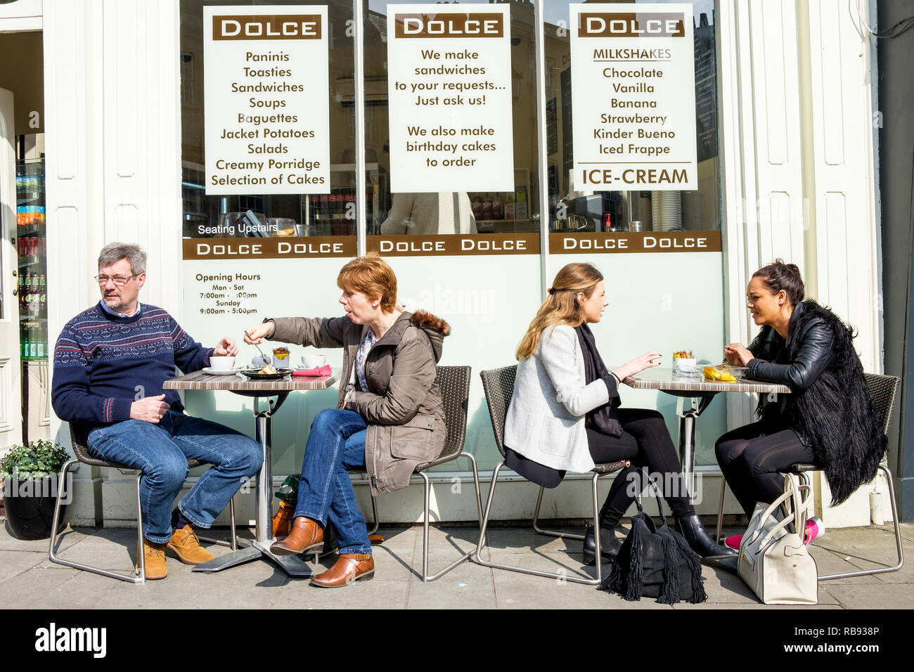 Die Menschen sind im Bild sitzt außerhalb eines High Street Kaffee Cafe trinken Kaffee und Essen in Bath, England, Großbritannien Stockfoto