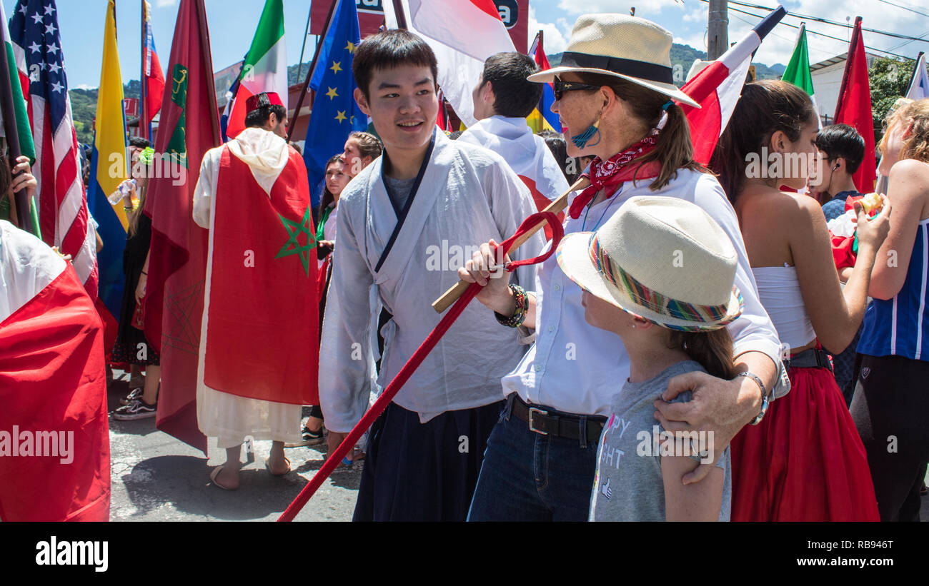 Feiern internationale Studierende für die Kamera posieren auf dem Hintergrund der verschiedenen nationalen Flaggen Stockfoto