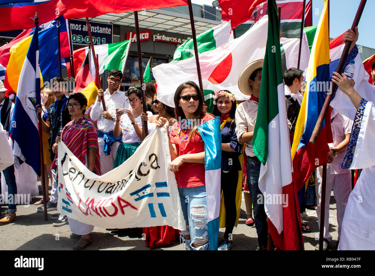 Ein nettes Foto von zahlreichen internationalen Studenten mit ihren nationalen Flaggen feiern. Stockfoto