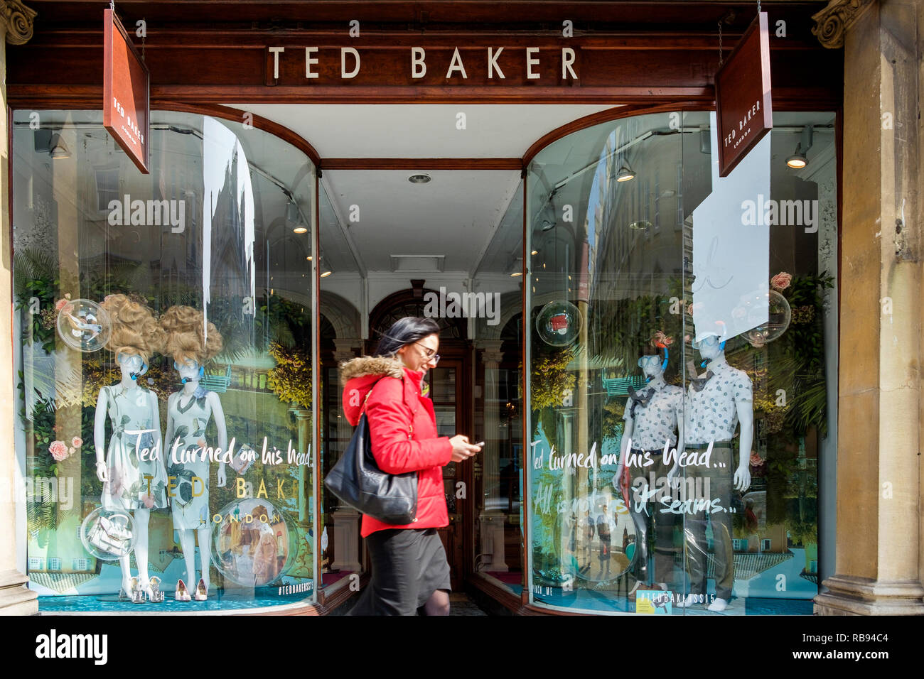 High Street Käufer sind Sie an einem Ted Baker mode kleidung shop Fenster in Bath, England, Großbritannien Stockfoto