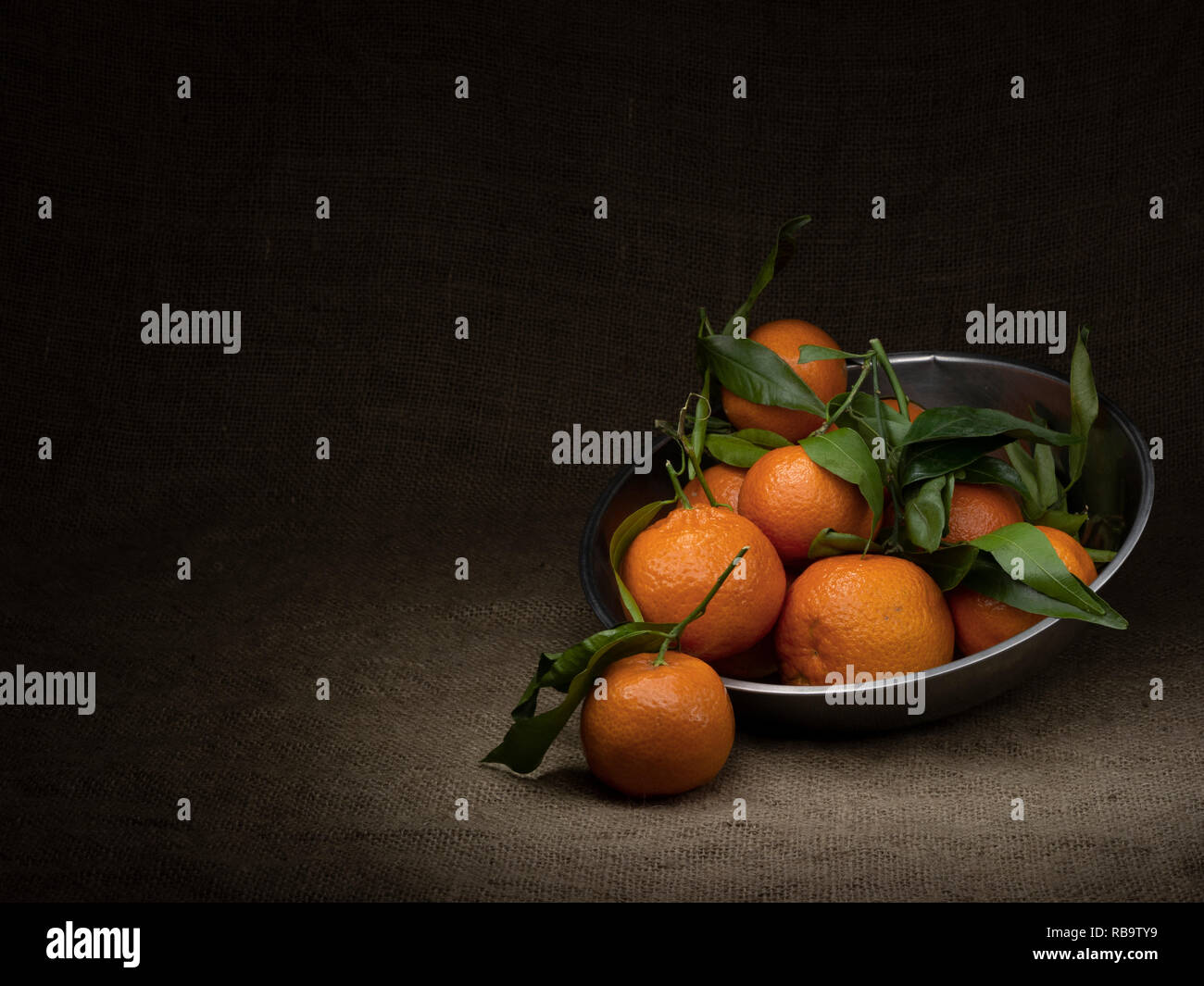 Orangen. Mehrere Obst in einem Metallbehälter, Licht mit Copyspace und Vignette-effekt gemalt. Stockfoto