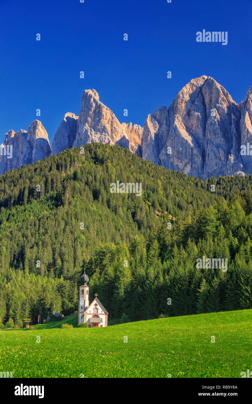 Die Kirche St. Johann in Ranui in der Villnoess/Villnöss Tal in den Dolomiten, Südtirol, Italien. Im Hintergrund die Geisler Gruppe Berge. Stockfoto