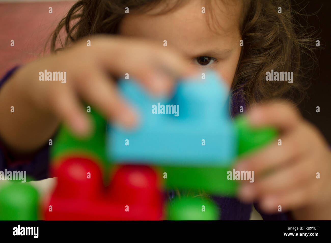 Junge Mädchen spielt mit Kunststoff Bausteine Stockfoto