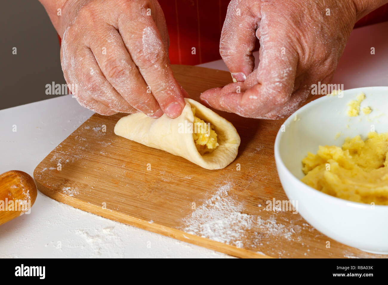 Close-up, hausgemachte Küche. Ältere Frau in Rot Küche Schürze formt Kartoffel Bratlinge Stockfoto Close-up, hausgemachte Küche. Ältere Frau in Rot Küche Schürze formt Kartoffel Bratlinge Stockfoto