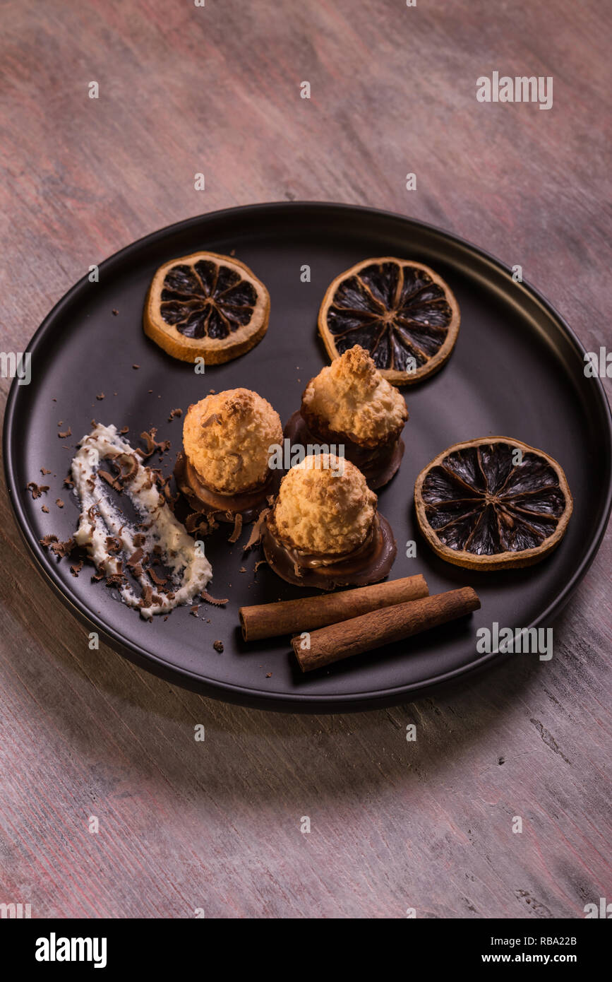 Vertikale Foto von wenigen Stücken von gebackenen hausgemachten Süßigkeiten. Konfektion hat schöne Kruste und Schokolade auf der Unterseite. Einige Stücke von Dry orange Ringe sind um auf Stockfoto